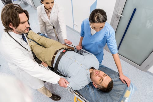 Preview: Cropped view of doctors transportating patient on gurney