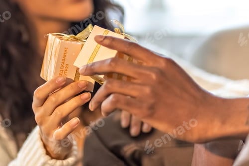 Preview: A happy couple of mulattoes exchange gifts with each other. Celebrating joint family events.