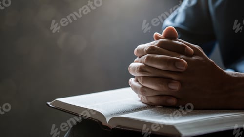 Preview: Hands together in prayer to God along with the bible In the Christian concept of faith, spirituality