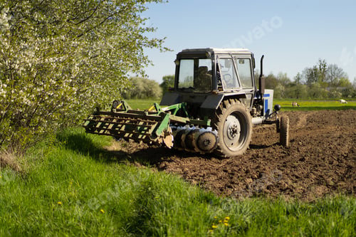 Preview: The tractor drives across the field and cultivates the land.