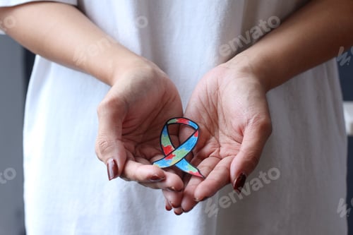 Preview: Close-up of colorful autism ribbon shape on palms