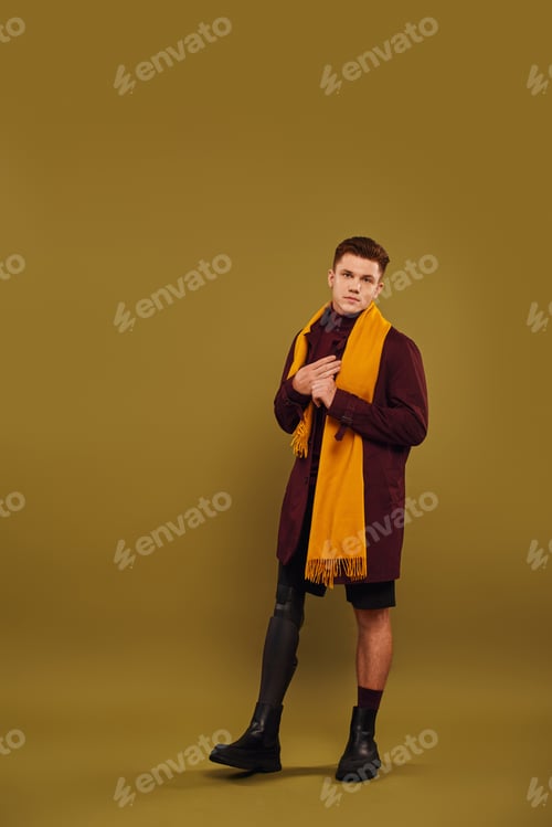 Preview: Handsome young man with prosthetic leg showcases trendy outfit in stylish studio setting