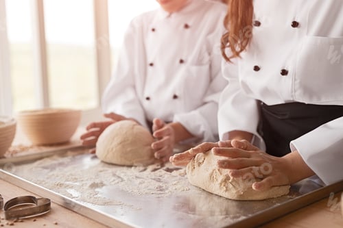 Preview: Unrecognizable bakers preparing dough for pastry