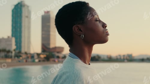 Preview: Close-up of young woman with short curly hair on the beach, smiling, enjoying life