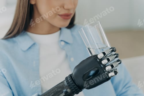 Preview: High technology robotic arm prosthesis. Handicapped european girl is holding glass of water.