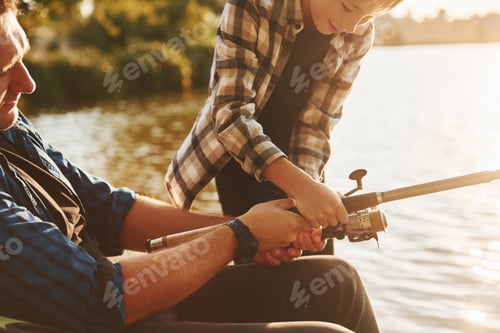 Preview: Sunny weather. Father and son on fishing together outdoors at summertime