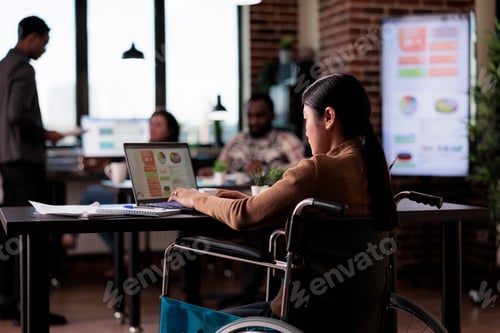 Preview: Asian woman with impairment working in disability friendly office
