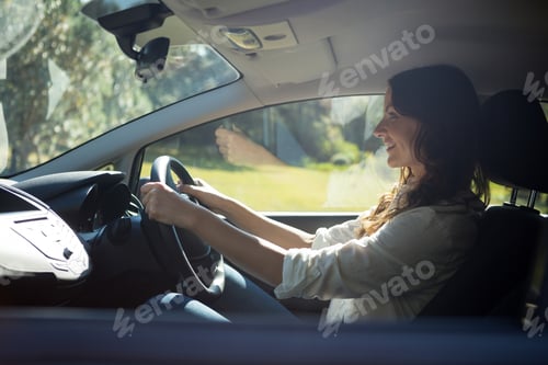 Preview: Smiling woman driving a car