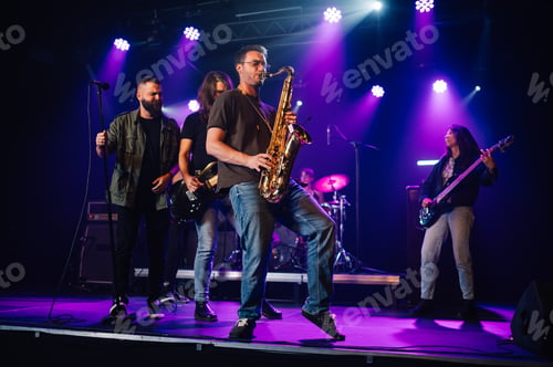 Preview: Music band playing live on stage during a concert, saxophone player in foreground
