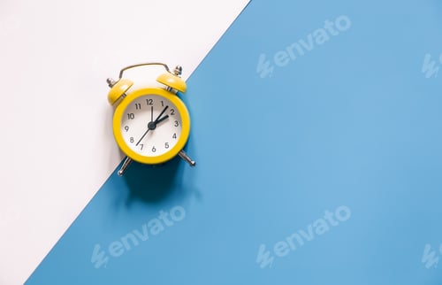 Preview: Yellow alarm clock on colored background isolated, flat lay.