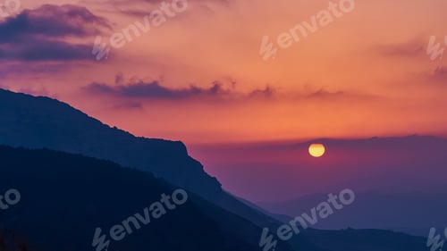 Preview: Sunset over layered mountain ridges and glowing sky