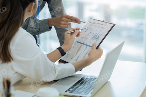 Preview: accountant team with laptop and paperwork analyzing financial data report