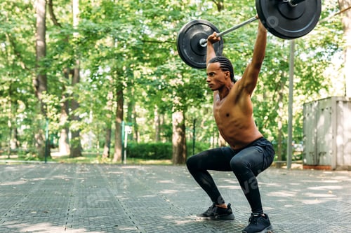 Preview: Young athlete performing deadlift exercise with weight bar outdoors