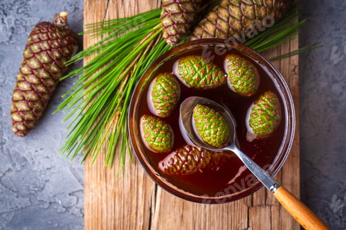 Preview: Young pine cones jam in glass bowl on wooden board. Delicious jam with the little pine cones.