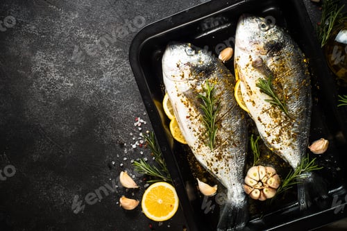 Preview: Raw fish dorado in baking sheet at black stone table