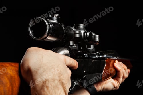 Preview: Male hands holding hunting rifle on black background