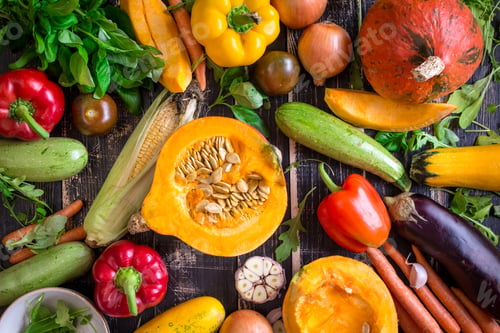 Preview: Fresh vegetables scaterred on a rustic dark textured table. Autumn background