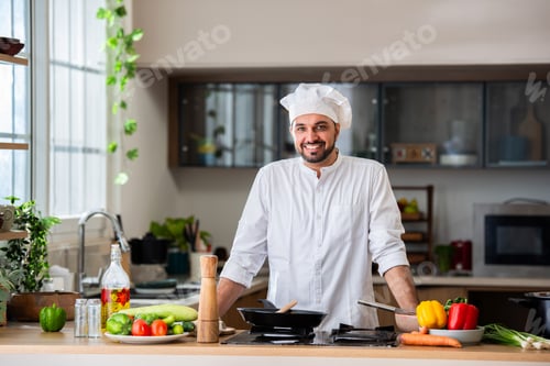 Preview: confident asian indian male young chef portrait in kitchen