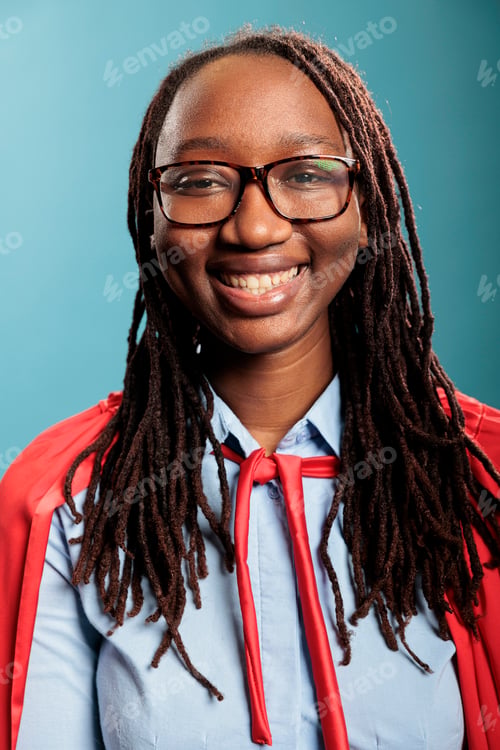 Preview: Portrait of happy cheerful smiling heartily young superhero woman wearing mighty hero red cape on