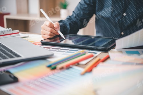 Preview: Graphic designer architects who work with laptops and color comparison tables for design work.