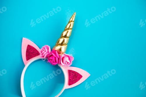 Preview: Unicorn horn on a rim with flowers on a blue background.