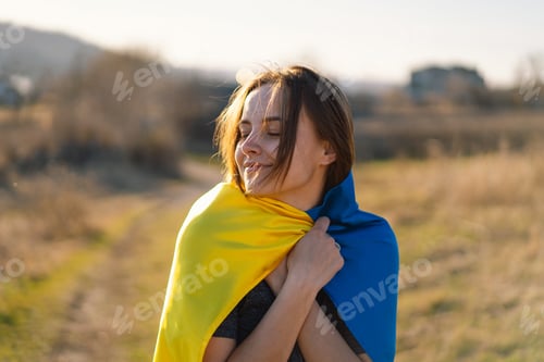 Preview: Woman holding a yellow and blue flag of Ukraine in outdoors
