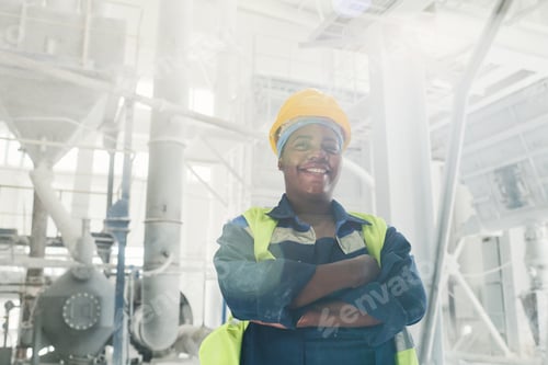 Preview: Young successful black female engineer in workwear and protective helmet
