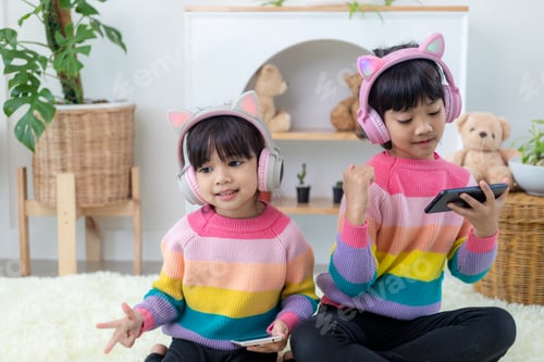 Preview: Little sibling girls listening music with headset happy together