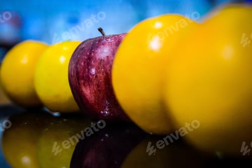 Preview: Red apple among yellow apples with a blurred background