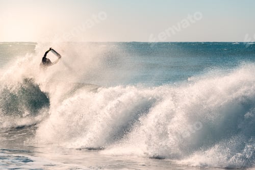 Preview: surfer jumping between the foam of a powerful wave