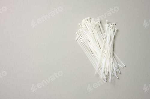 Preview: Stack of plastic cable ties on gray background. View from above