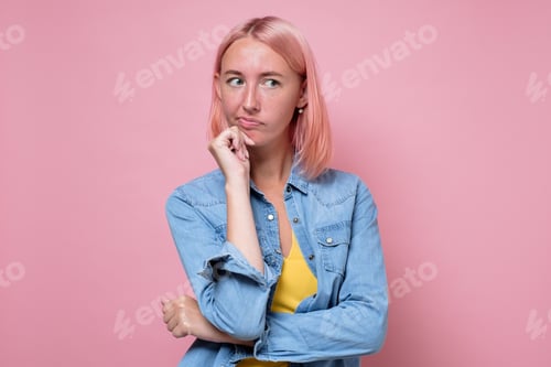 Vista previa: Pensive young woman with dyed pink hair looking aside