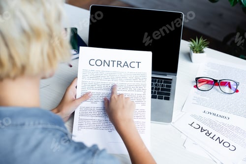 Preview: back view of woman pointing with finger at contract