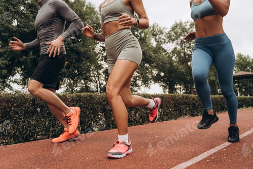 Preview: Closeup, active, fit athlete wearing sportwear running together outdoors. Sport, motivation concept