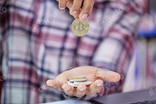 Preview: How much is it worth to you. Shot of an unrecognisable man holding bitcoins.