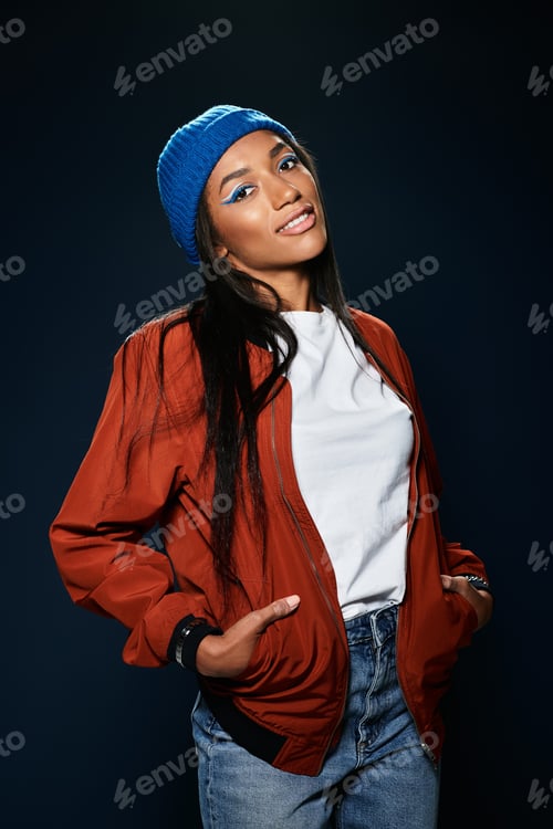Preview: A young woman showcases stylish autumn fashion while smiling against a dark backdrop
