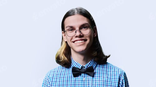 Preview: Headshot portrait of smiling teenage guy on light studio background