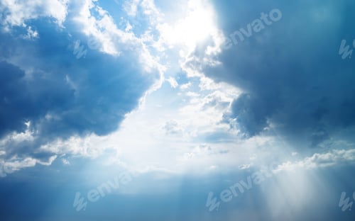 Preview: Blue dramatic sky background with clouds and sun rays coming out.