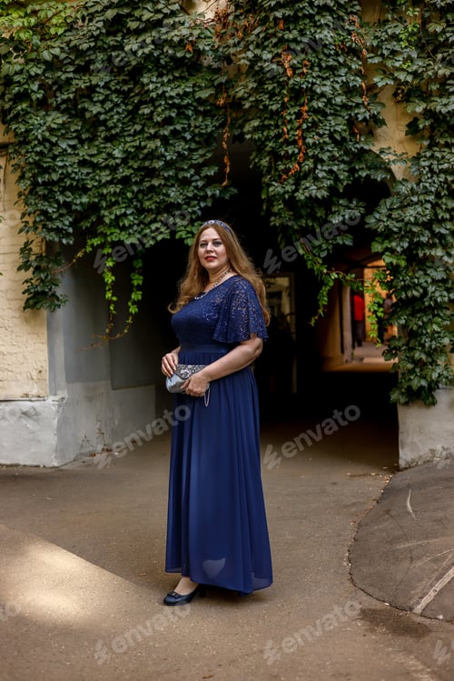 Preview: Woman in a long blue dress in the garden.