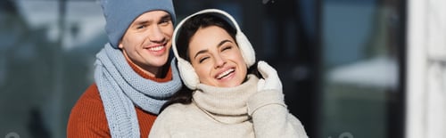 Preview: happy young couple in winter outfit smiling outside, banner