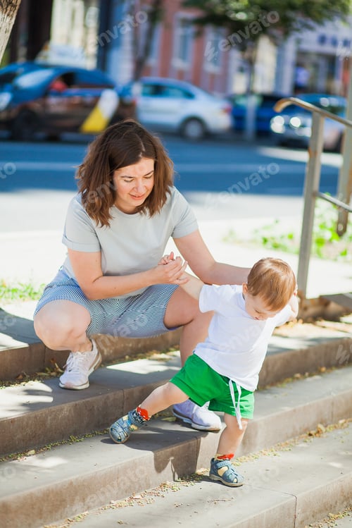 Preview: Young woman helps her son with first steps.