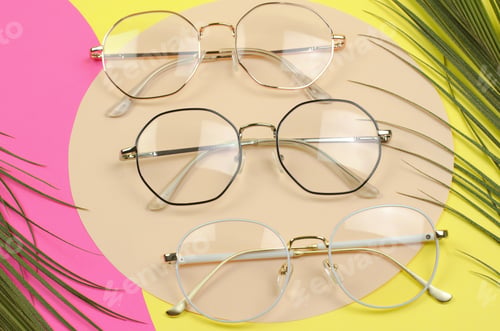 Preview: Stylish glasses on a colored background with palm leaves. Set of eyeglasses, selective focus