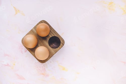 Preview: Three brown eggs in a wooden storage organizer box