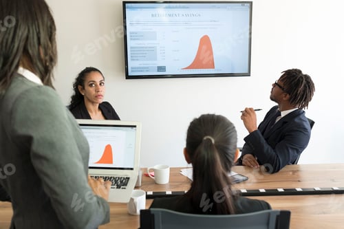 Preview: Businessman and businesswomen, in office, looking at data graphs