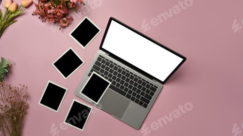 Preview: Top view of laptop computer, blank photo frames and beautiful blooming flower bouquet.