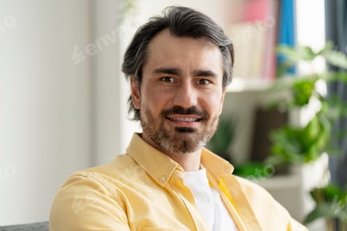 Preview: Portrait of smiling middle-aged businessman relaxing at home office