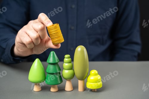 Preview: Businessman holding coins over trees. Green bonds