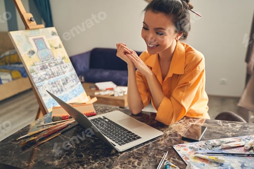 Preview: Cute smiling lady talking with friend through video call