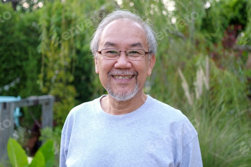Preview: Portrait of happy senior man looking camera at home