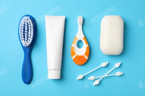 Preview: Flat lay composition with baby toothbrush and toiletries on color background